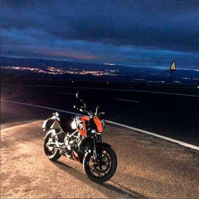 Moto KTM de noche con vistas a la ciudad