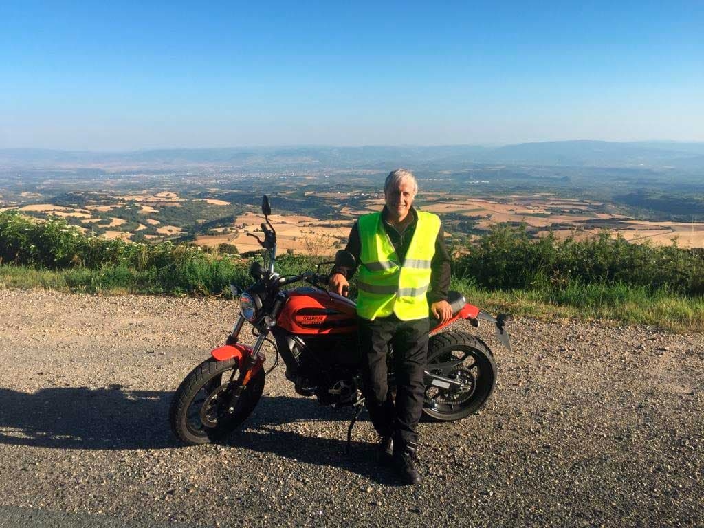 Instructor con moto en paisaje panorámico